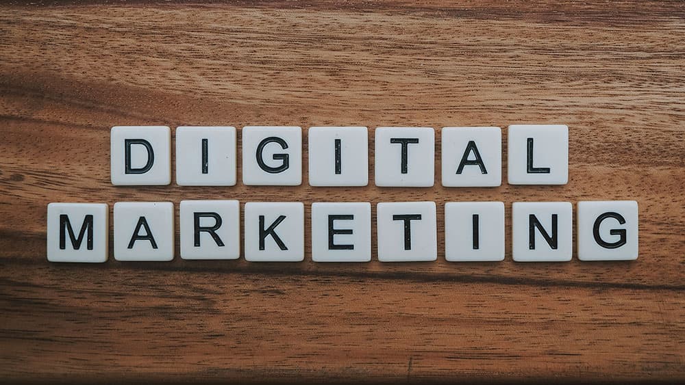 Wooden letter tiles spelling digital marketing on a table